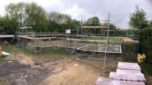 scaffolding surrounding a building foundation for construction - image 2